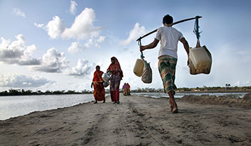 Rural villagers walk to and from a water well in Shatkhira, Bangladesh. 2010.